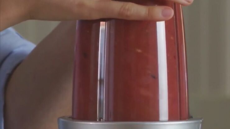 Person Using a Blender with A Container Filled with A Red Liquid